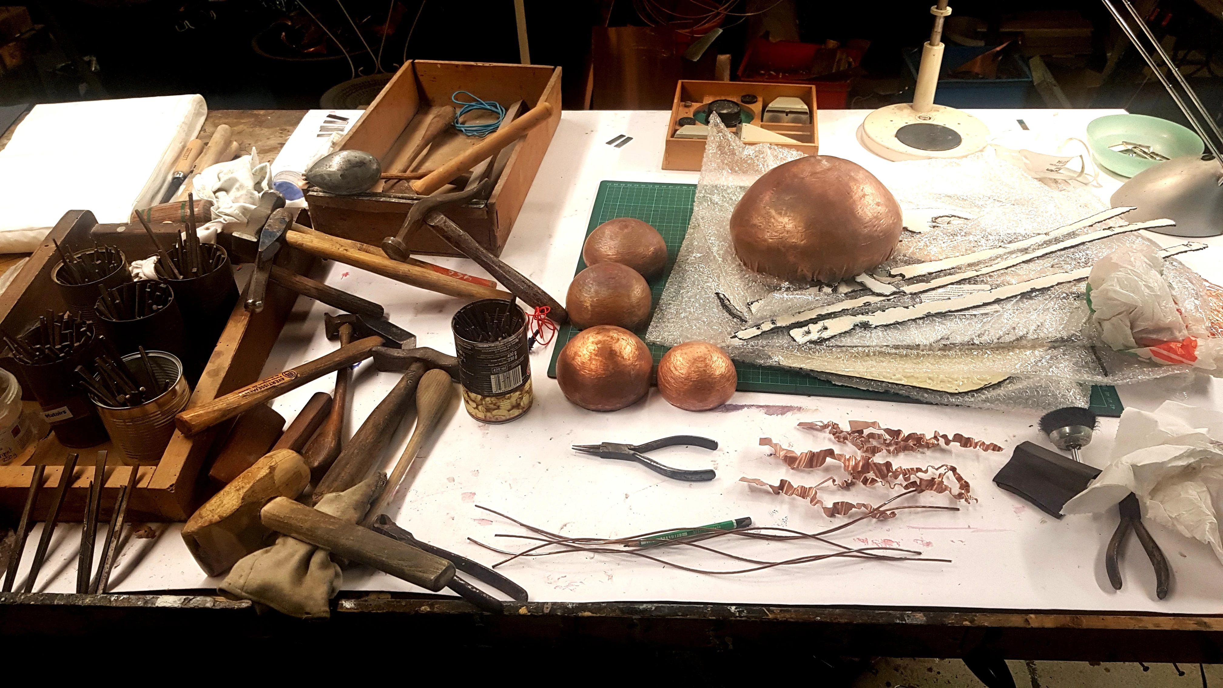 Pièces de dinanderie en cours de réalisation.